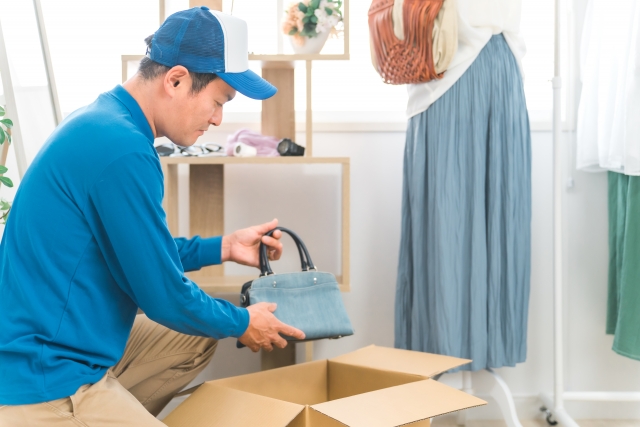 引越し業者が段ボールに荷物を詰めている様子